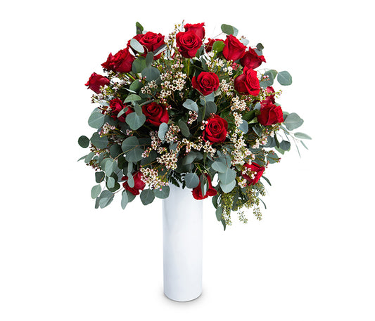 Large cylindrical vase with 36 red roses and greenery.