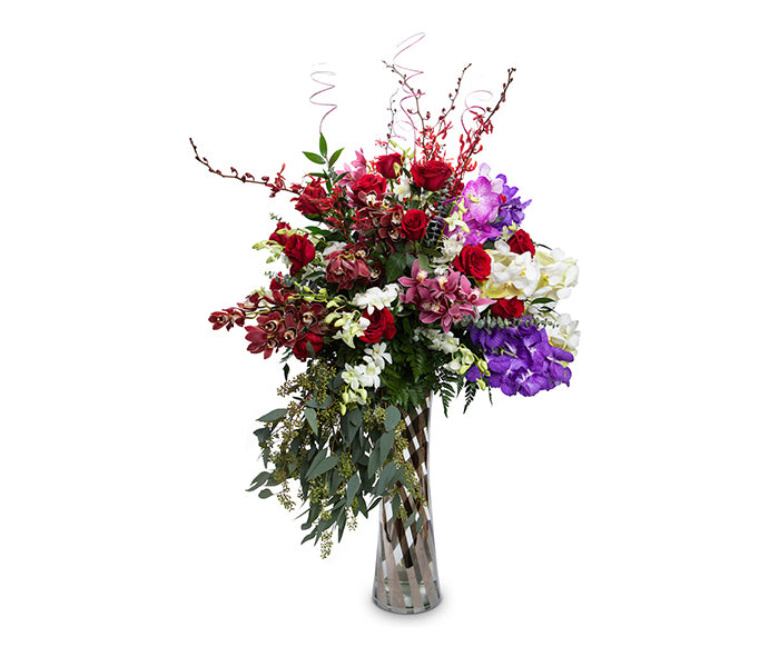 Large vase with hydrangeas, roses and orchids with cascading greenery.