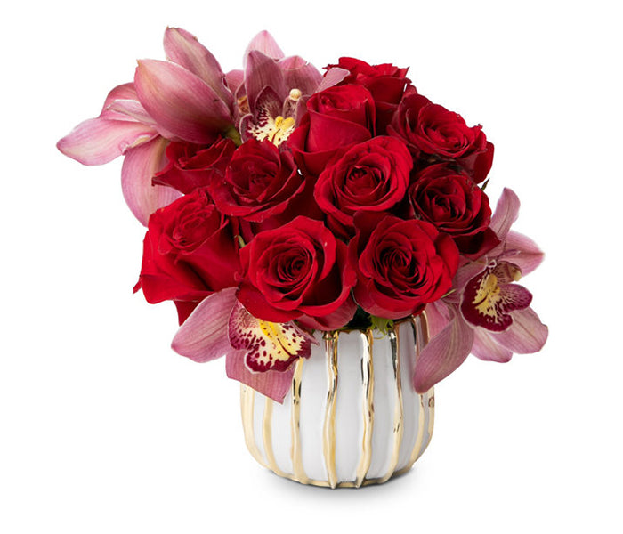 Small gold and white vase with 12 Red roses with cymbidium orchid blooms.